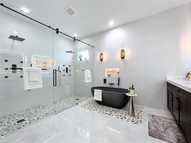 bathroom with vanity, independent shower and bath, and tile walls