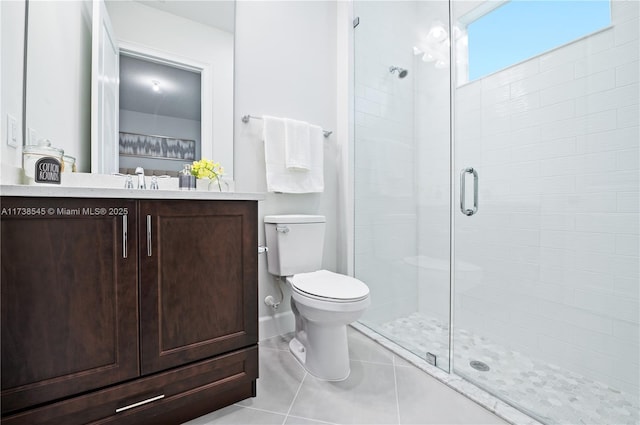 bathroom with an enclosed shower, vanity, tile patterned flooring, and toilet