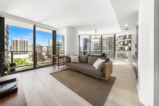 living room featuring a wall of windows and light hardwood / wood-style floors