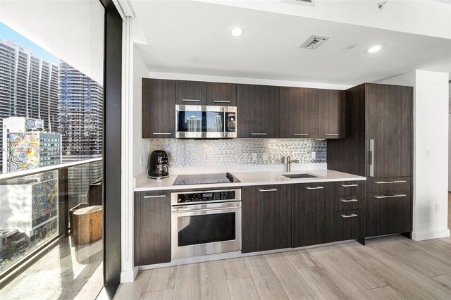 kitchen featuring dark brown cabinetry, sink, and appliances with stainless steel finishes