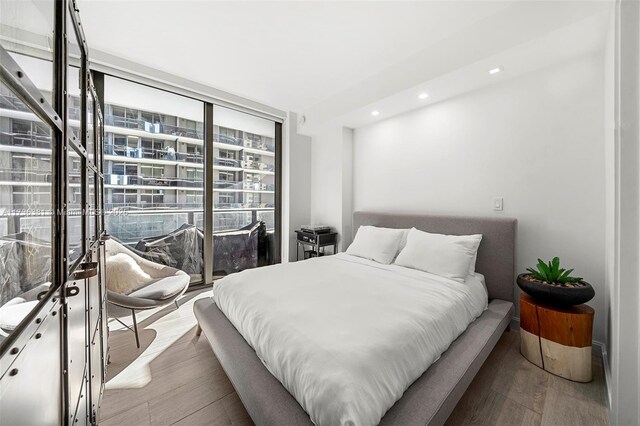 bedroom featuring expansive windows and light wood-type flooring