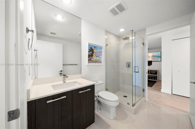 bathroom featuring vanity, an enclosed shower, and toilet