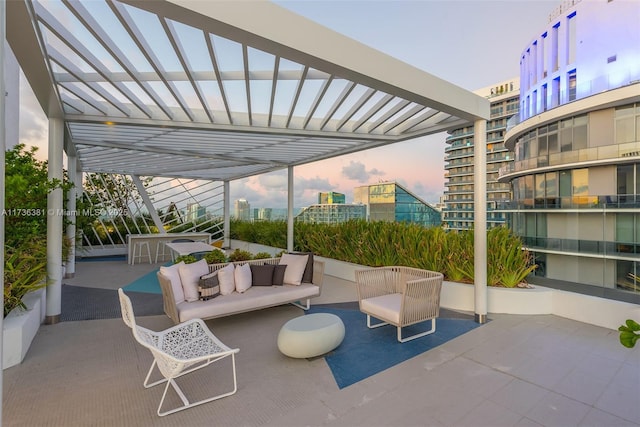 patio terrace at dusk with a pergola and outdoor lounge area