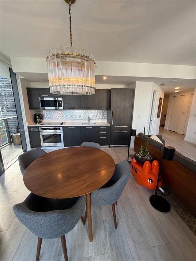 dining space with sink and light wood-type flooring