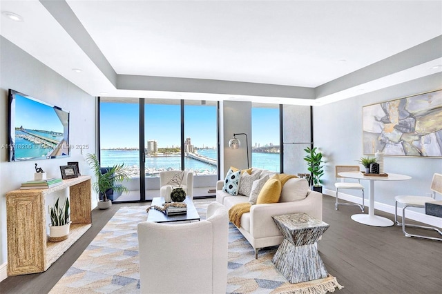 living room featuring wood-type flooring, a water view, and a wealth of natural light