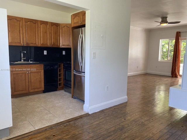 kitchen with sink, stainless steel refrigerator, dishwasher, tasteful backsplash, and light wood-type flooring