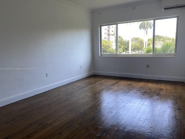 spare room with dark hardwood / wood-style flooring, crown molding, and an AC wall unit