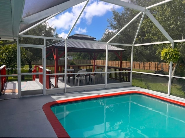 view of pool featuring a playground, glass enclosure, and a patio area