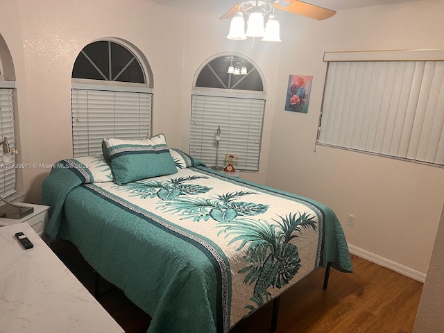 bedroom featuring ceiling fan, baseboards, and wood finished floors