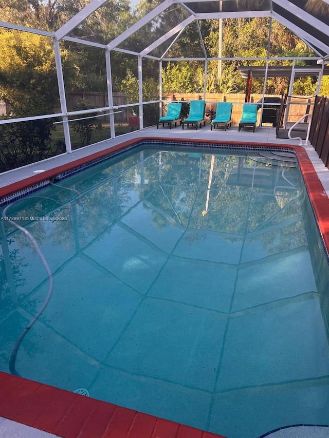 view of pool featuring a patio area, a fenced in pool, a lanai, and fence