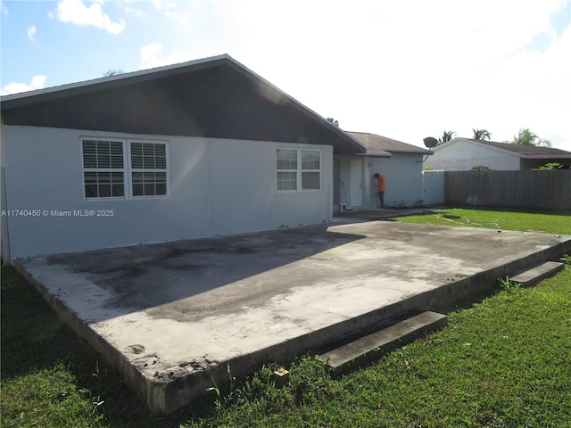 rear view of house with a lawn and a patio area