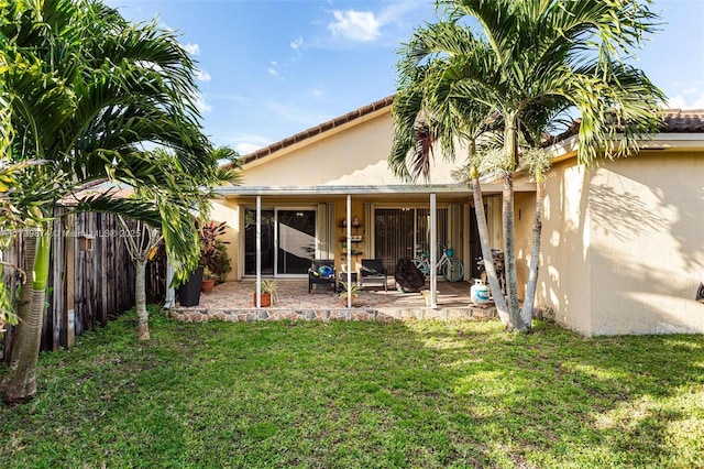 rear view of house featuring a yard and a patio area