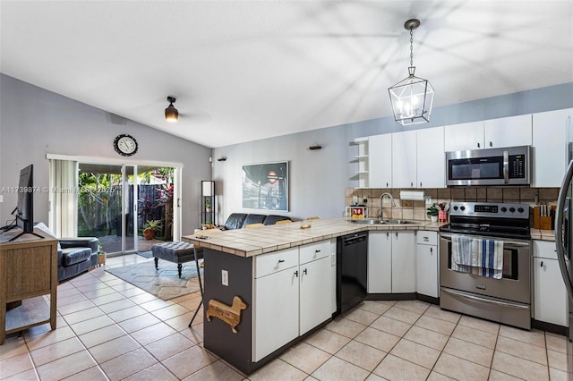 kitchen featuring appliances with stainless steel finishes, white cabinets, pendant lighting, and kitchen peninsula