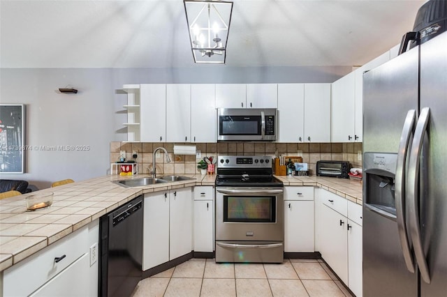 kitchen featuring sink, tile countertops, white cabinetry, and stainless steel appliances