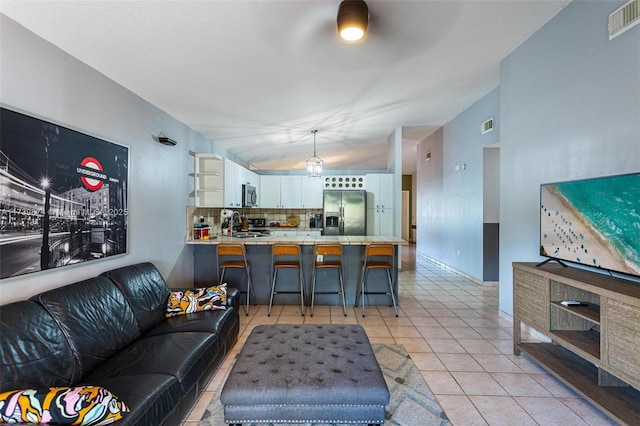 living room with light tile patterned floors, sink, and lofted ceiling