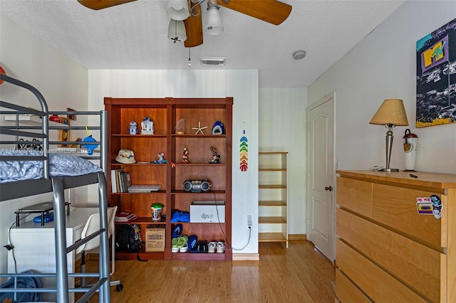 bedroom with a textured ceiling and hardwood / wood-style floors