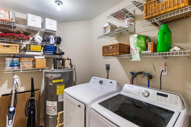 laundry room featuring electric water heater, independent washer and dryer, and a textured ceiling