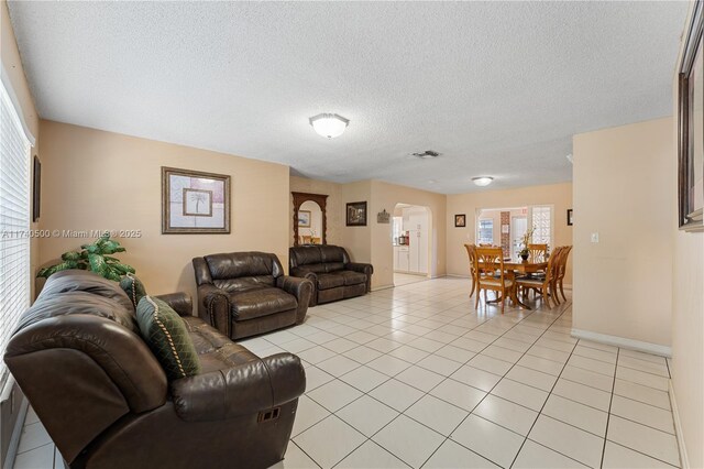 living room featuring light tile patterned flooring and a textured ceiling