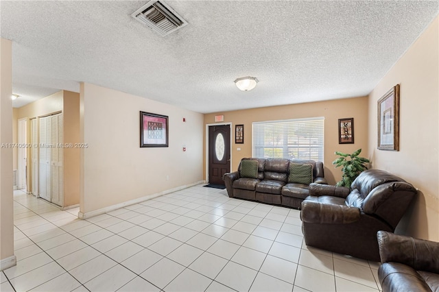 living room with a textured ceiling and light tile patterned floors