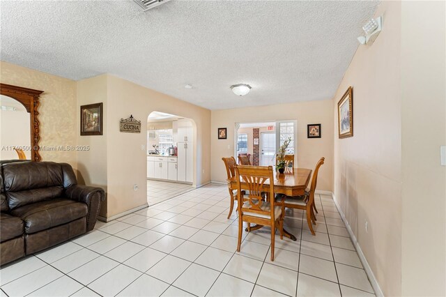 dining space with light tile patterned flooring and a textured ceiling