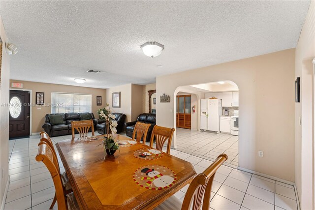 tiled dining space featuring a textured ceiling