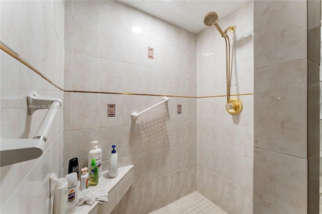 bathroom featuring a tile shower and a textured ceiling