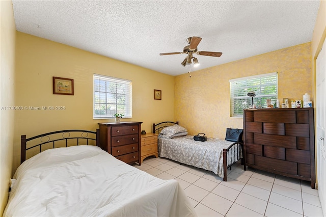 tiled bedroom with ceiling fan and a textured ceiling