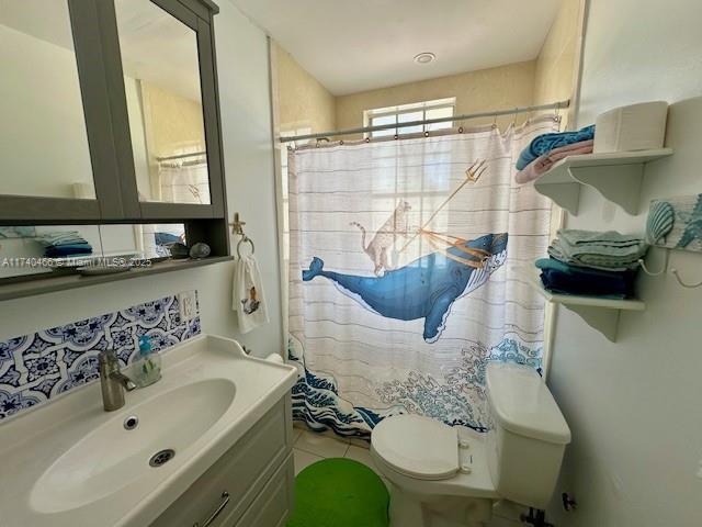 bathroom featuring vanity, toilet, and a shower with shower curtain