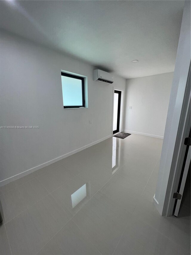 tiled spare room with an AC wall unit