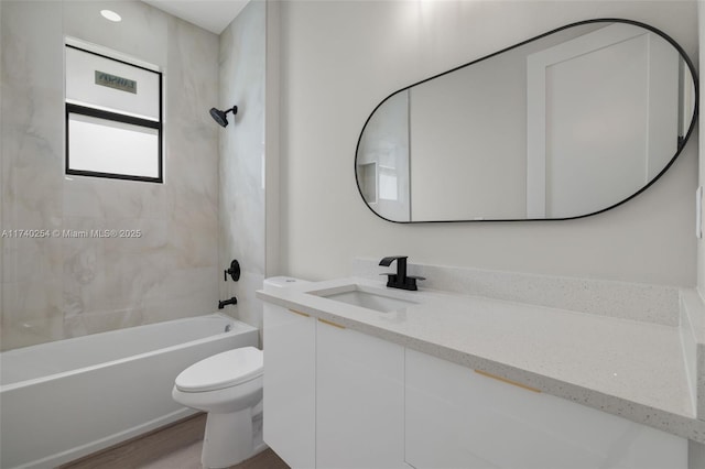 full bathroom featuring vanity, tiled shower / bath combo, wood-type flooring, and toilet