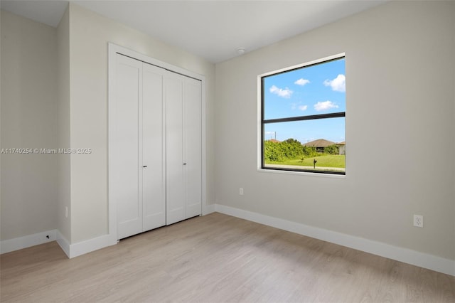 unfurnished bedroom featuring light hardwood / wood-style floors and a closet