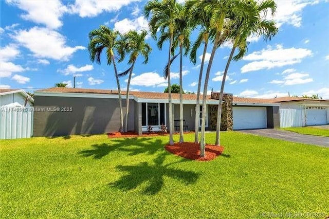 single story home featuring a garage and a front yard