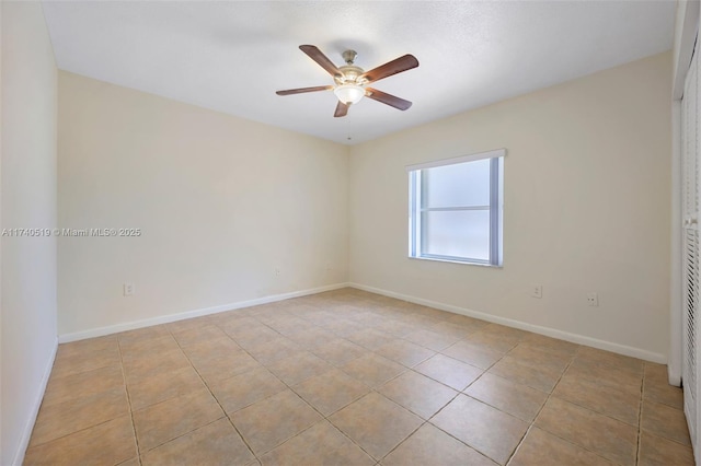 empty room with ceiling fan and light tile patterned floors