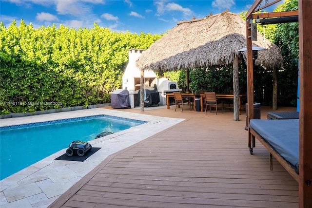 view of swimming pool featuring a gazebo, grilling area, and a deck