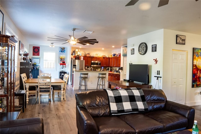 living room with ceiling fan and light hardwood / wood-style flooring