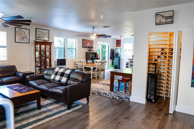 living room with dark wood-type flooring and ceiling fan