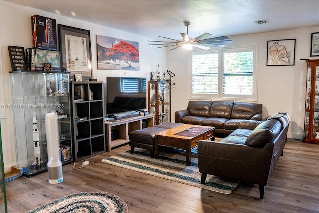 living room featuring wood-type flooring and ceiling fan