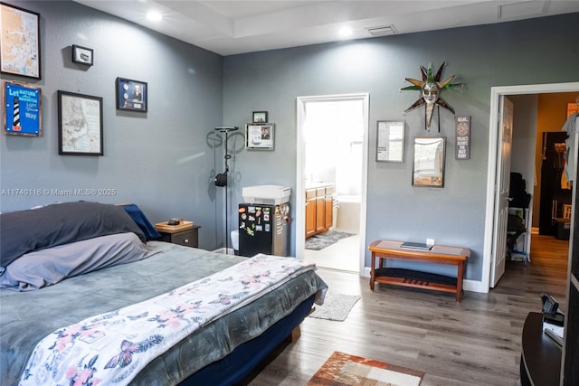 bedroom featuring wood-type flooring and connected bathroom