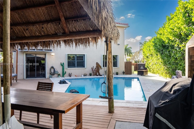 view of pool featuring a wooden deck and grilling area