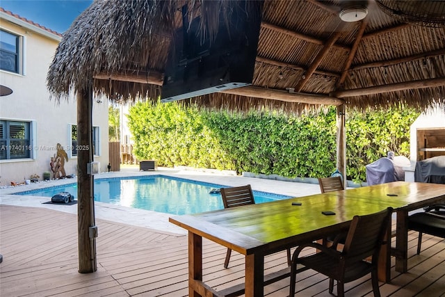 view of pool with area for grilling, a wooden deck, a gazebo, and ceiling fan