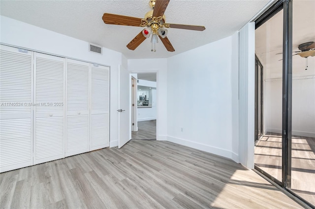 unfurnished bedroom with a closet, ceiling fan, a textured ceiling, and light hardwood / wood-style flooring