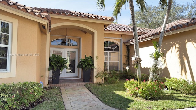 entrance to property with a lawn and french doors