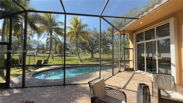 view of swimming pool with a lanai, a lawn, and a patio