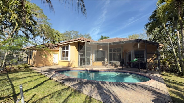 back of house featuring a lanai, a patio, and a lawn