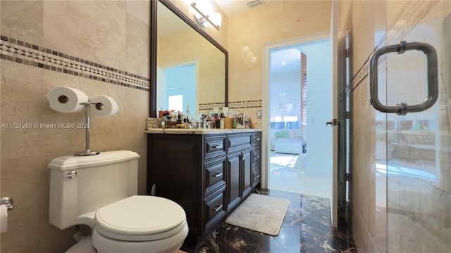 bathroom featuring tile walls, vanity, and toilet