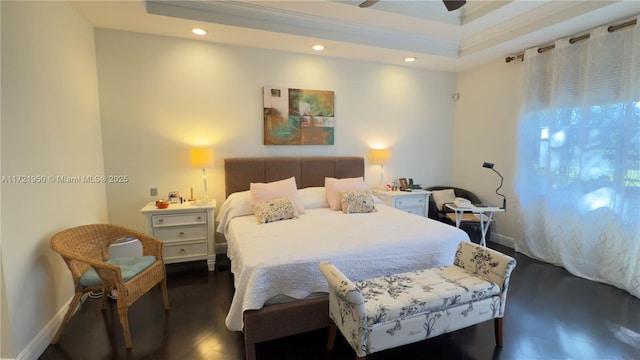 bedroom featuring a raised ceiling and dark hardwood / wood-style floors