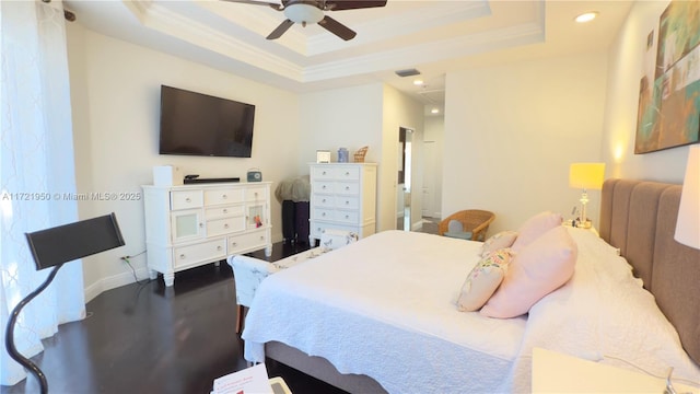 bedroom with hardwood / wood-style flooring, crown molding, ceiling fan, and a tray ceiling