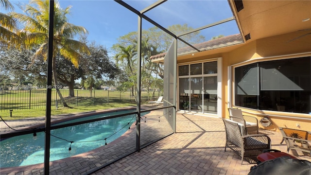 view of pool with glass enclosure and a patio area