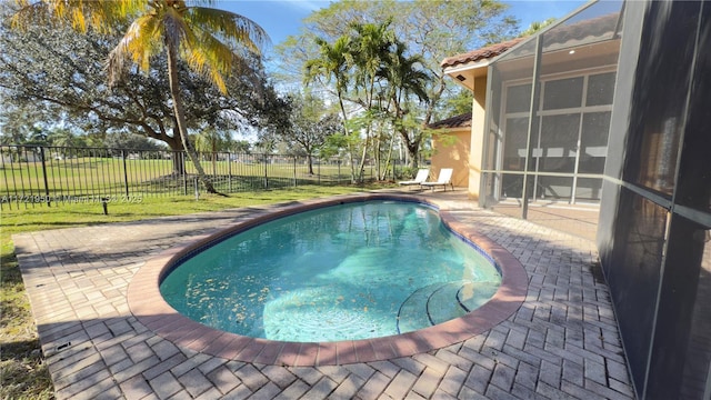 view of swimming pool featuring a yard, a lanai, and a patio area