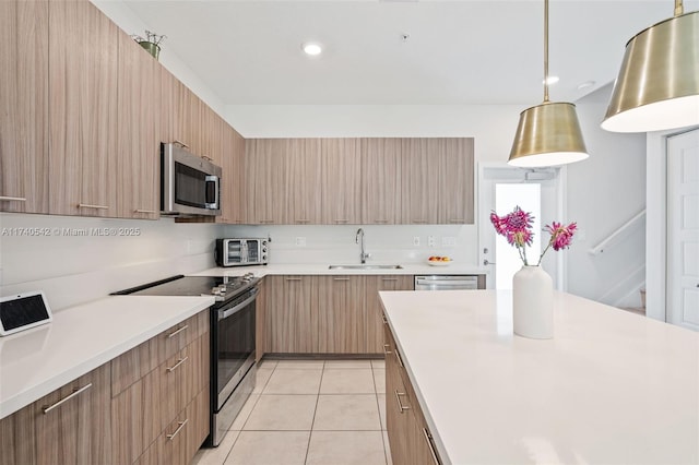 kitchen with sink, decorative light fixtures, stainless steel appliances, and light tile patterned floors